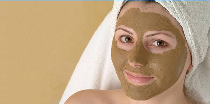 Meisje met een cosmetische masker op haar gezicht.