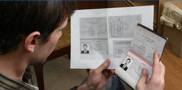 Paspoort en fotokopie in de handen van een man