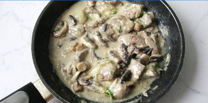 Kippenlever met champignons in een zure roomsaus in een pan