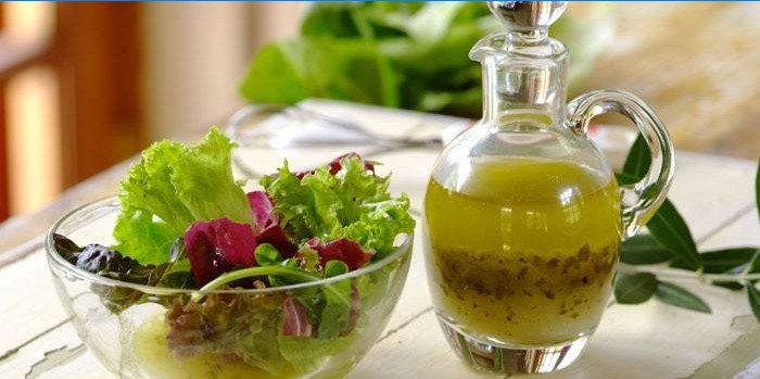 Saladebladeren in een kom en kant-en-klare dressing voor dressing