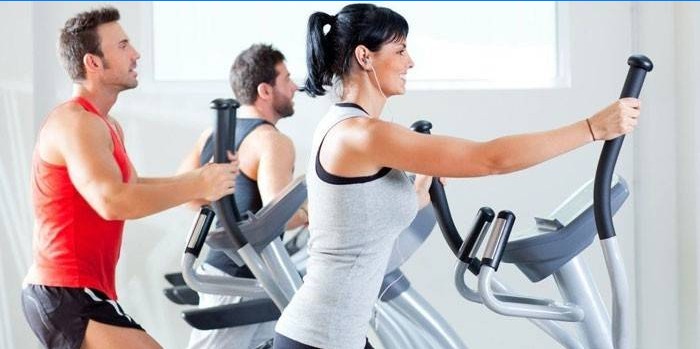 Mannen en vrouwen trainen op elliptische trainers.