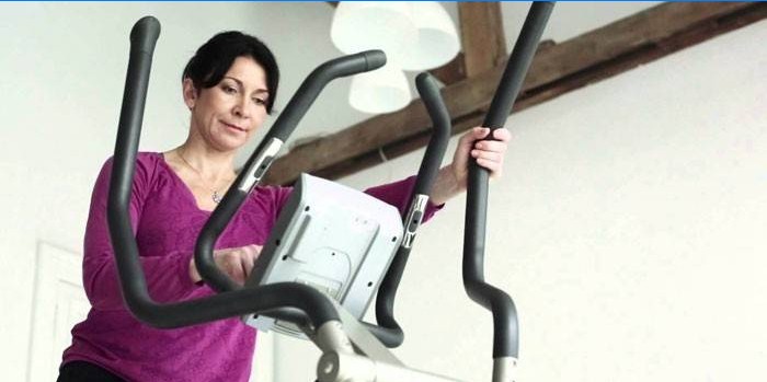 Vrouw zet oefenprogramma op ellipsoïde