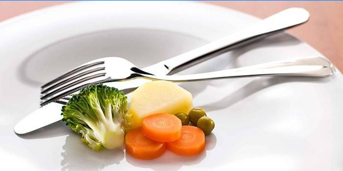 Klein gedeelte groenten op een plaat en vork