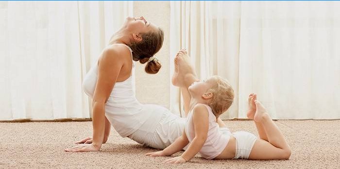 Moeder en baby doen thuis yoga.