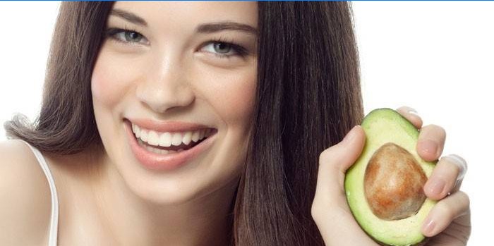 Het meisje houdt avocado in hand