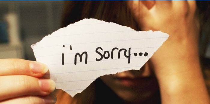 Meisje met een briefje "Sorry"