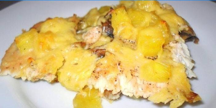 Een stuk kip met aardappelen, ananas en kaas