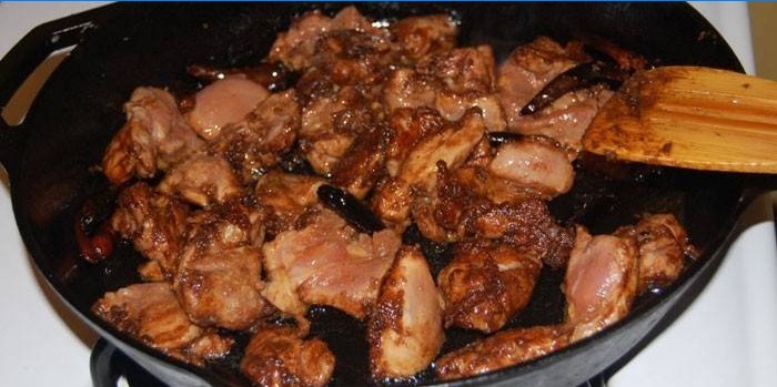 Stukjes kip in een sojasaus in een pan
