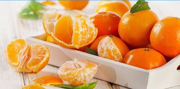 Gepelde en gepelde mandarijnen op een dienblad