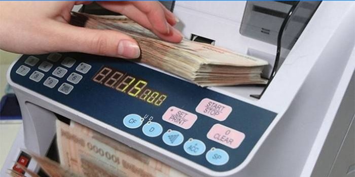 Vrouw telt geld met een rekenmachine