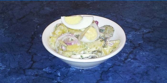 Salade van aardappelen, gekookte eieren en augurken