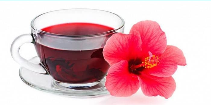Beker met thee en hibiscus bloem