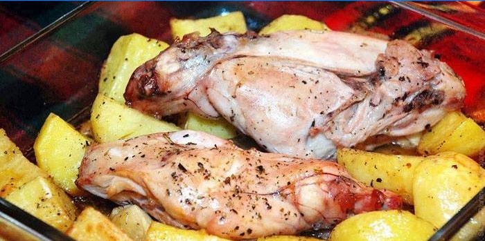 Konijnenvlees op een kussen van aardappelen voor het bakken