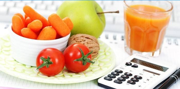 Fruit, groenten, een glas sap en een rekenmachine