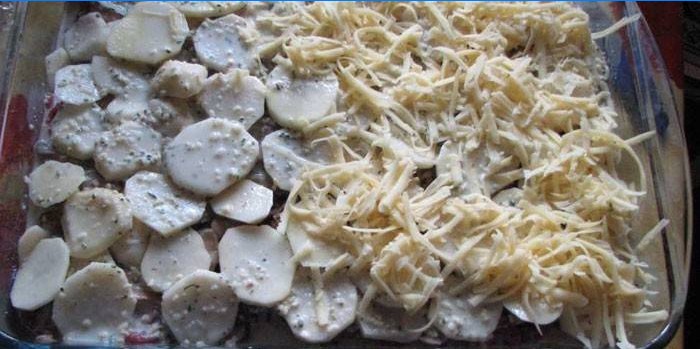 Laag van aardappel en kaas in de vorm voor het bakken