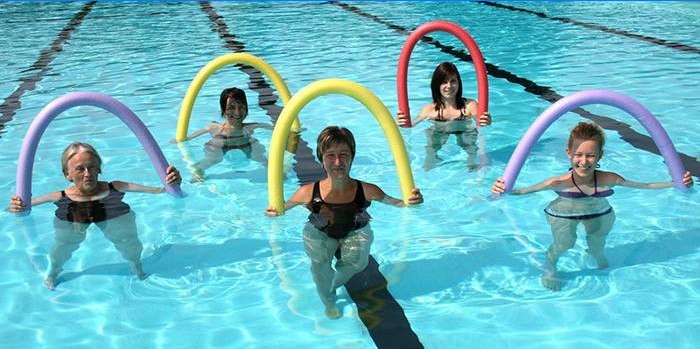 Vijf vrouwen met noedels in het zwembad