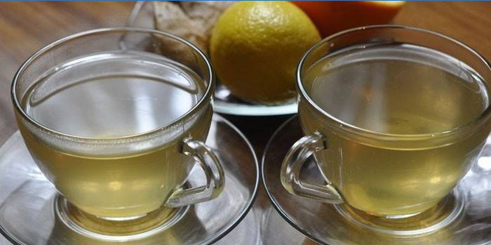 Twee kopjes groene thee met gember en sinaasappel.