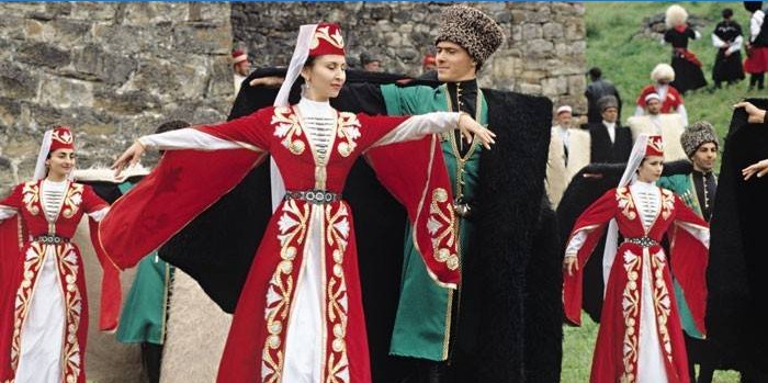 Vrouwen en mannen in Tsjetsjeense kostuums dansen