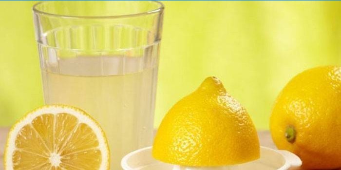 Citroensap in een glas en citroenen
