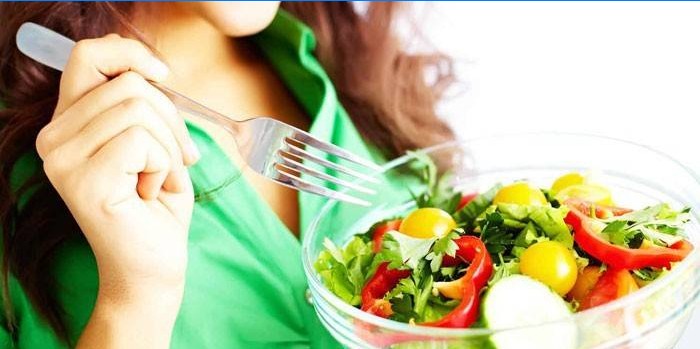 Meisje eet groente salade