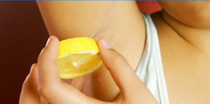 Vrouw wrijft oksels met citroen