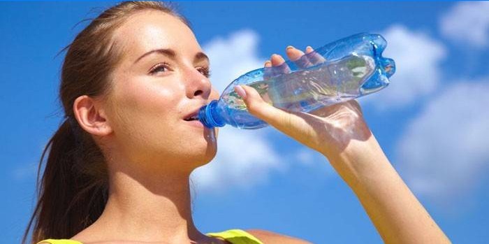 Meisje drinkt water uit een fles