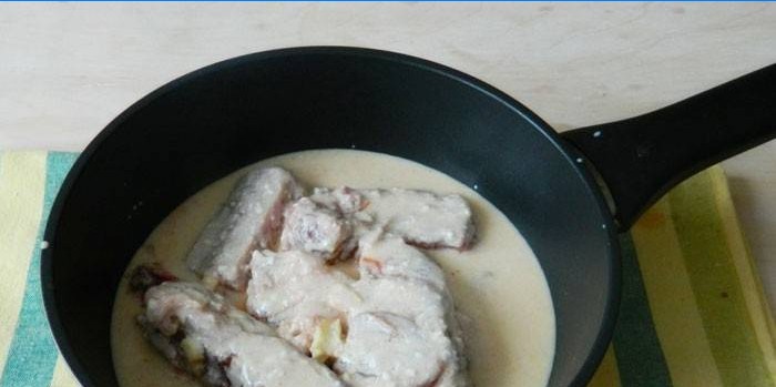 Varkensribbetjes in een romige saus in een pan