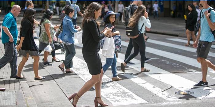 Meisje met een telefoon bij een voetgangersoversteekplaats