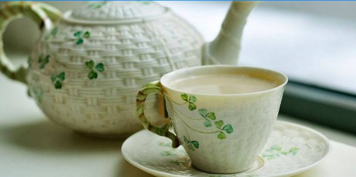 Groene thee met melk in een kopje en theepot
