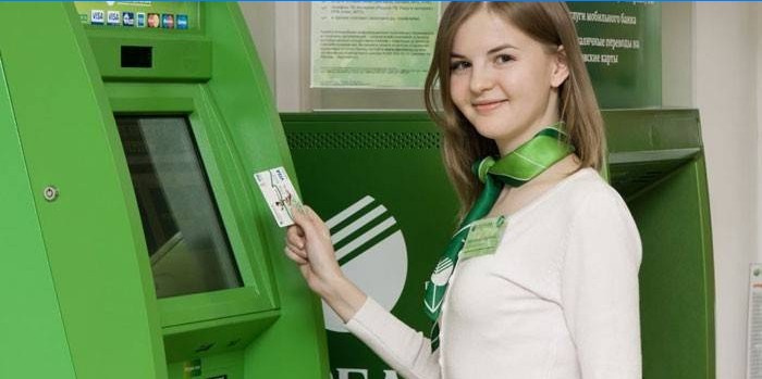 Sberbank-medewerker met een kaart in de hand voor de terminal