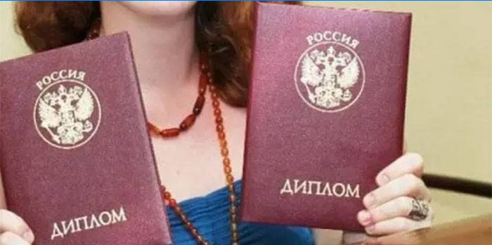 Een meisje met twee diploma's in haar handen