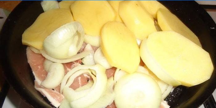 Vlees, uien en aardappelen in een pan
