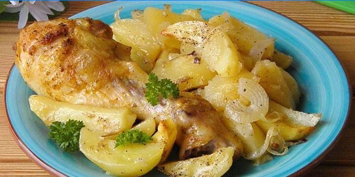 Kippentrommelstok met aardappels en uien op een plaat