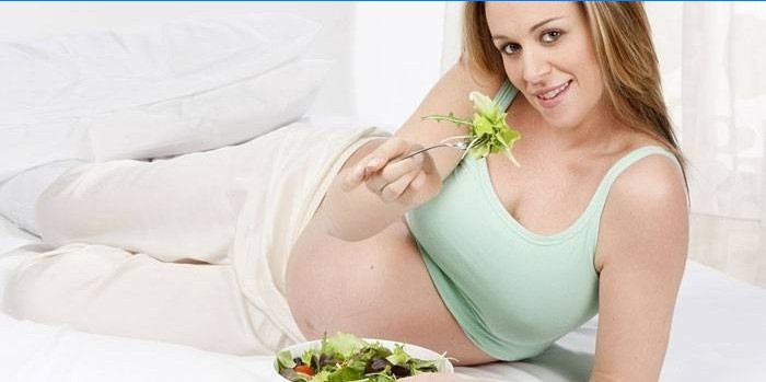 Zwanger meisje eet salade