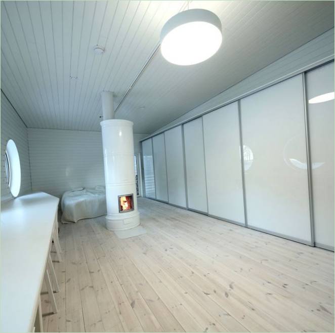 De slaapkamer van een modern boshuis in Finland