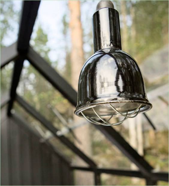 Een kroonluchterlamp in het interieur van een glazen tuinhuisje