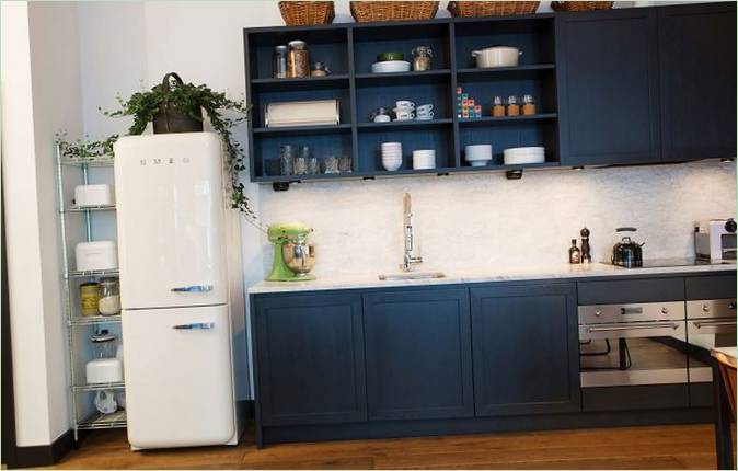 Zwart keukenblok en witte retro koelkast in een woning van Stråhattfabriken in Stockholm